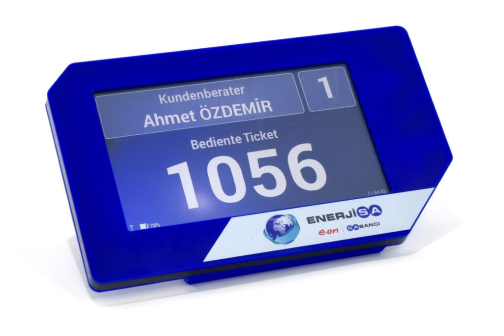 Kleines Tischdisplay zeigt aktuelle Wartenummer und Beratername im EnerjiSA Kundenservice